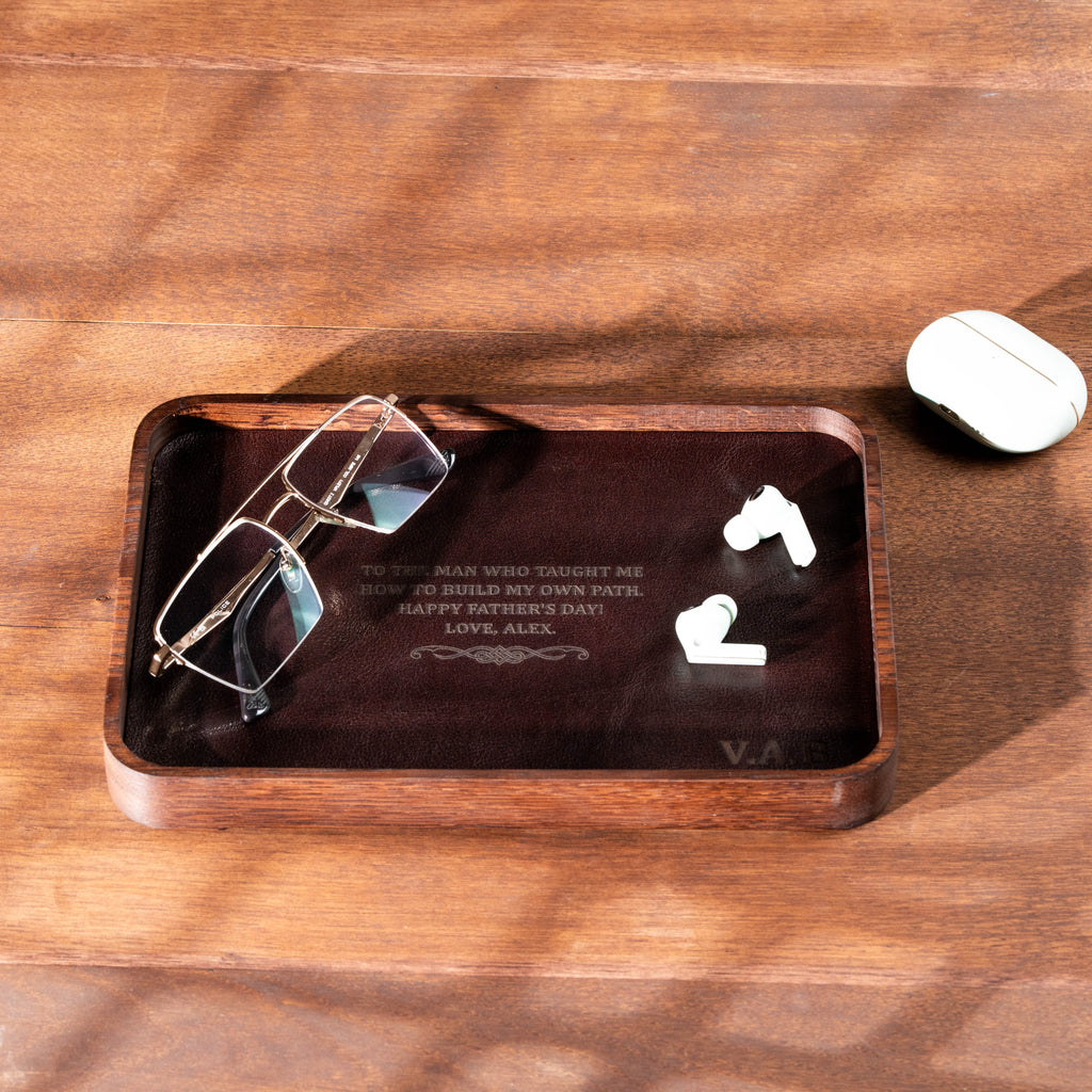 Personalized dark oak valet tray with cognac leather and custom engraved message.